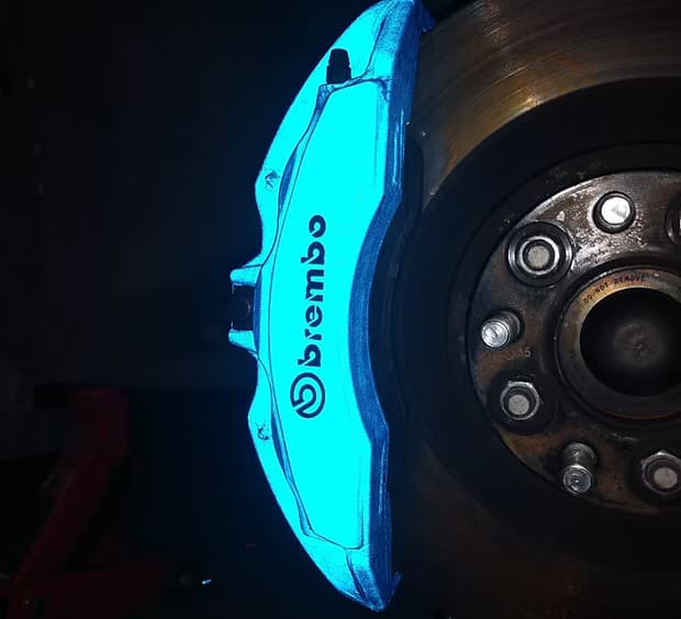 Reflective caliper finish — metallic coating catching light through spokes